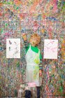 Boy in front of paint splattered wall — Stock Photo