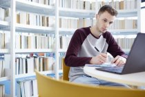 Young University student working in library — Stock Photo