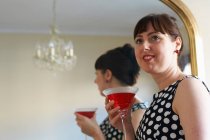 Woman drinking cocktail by mirror, selective focus — Stock Photo