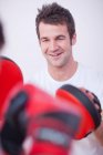 Close up of personal trainer with client in gym — Stock Photo