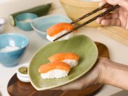 Woman holding plate of sushi — Stock Photo