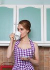 Жінка має чашку кави на кухні — стокове фото