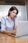 Businesswoman on cell phone and laptop — Stock Photo