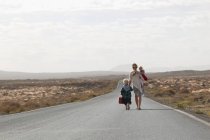 Мать и дети на сельской дороге — стоковое фото