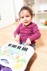 Menina tocando com piano de brinquedo — Fotografia de Stock