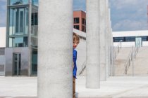 Boy peering out from behind column — Stock Photo