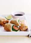 Dish of egg and salmon rolls with dip — Stock Photo