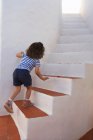 Rear view of girl carefully climbing steps — Stock Photo