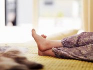 Обрезанный снимок ног девочки на кровати — стоковое фото