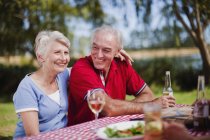 Older couple sitting at picnic table — Stock Photo
