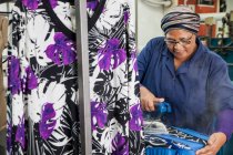 Arbeiter bügelt Kleid in Bekleidungsfabrik — Stockfoto
