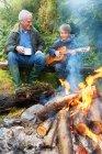 Grandfather and grandson by campfire — Stock Photo