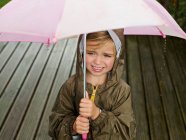 Una giovane ragazza sotto un ombrello — Foto stock