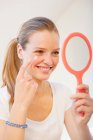 Adolescente aplicación de maquillaje en el espejo - foto de stock