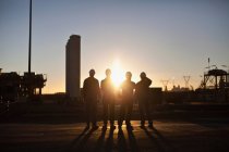 Silhouette of workers at oil refinery — Stock Photo