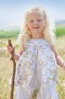 Маленькая девочка, стоящая в высокой траве — стоковое фото