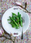 Top view of plate of asparagus with flowers on table — Stock Photo