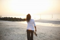 Vue arrière de la femme se promenant sur la plage, Dubaï, Émirats arabes unis — Photo de stock