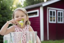 Retrato de una niña comiendo ensalada en el jardín, Baviera, Alemania - foto de stock