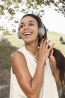 Счастливая молодая женщина слушает музыку в наушниках — стоковое фото