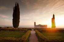 Cespugli curati giardino con vista castello al tramonto — Foto stock
