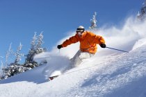 Людина катається на лижах вниз по схилу — стокове фото