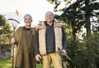 Senior couple holding rake and pruner — Stock Photo