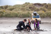 Família com dois meninos brincando na praia — Fotografia de Stock
