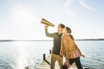 Пара використовує мегафон біля озера — стокове фото