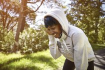 Молода жінка в сільській місцевості, одягнена в светр з капюшоном, посміхається — стокове фото