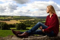 Porträt einer jungen Frau mit Blick über die ländliche Landschaft — Stockfoto