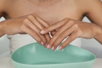 Woman's hands in bowl of water — Stock Photo
