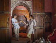 Young couple in riad making a toast in archway, Marrakesh, Morocco — Stock Photo