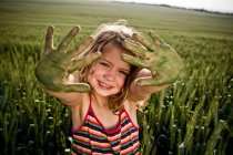 Mädchen mit bemalten grünen Händen — Stockfoto