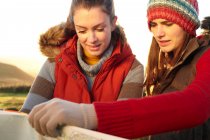Mujeres leyendo mapa al aire libre, se centran en primer plano - foto de stock