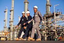 Trabalhadores que caminham na refinaria de petróleo — Fotografia de Stock