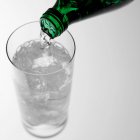 Verser de l'eau pétillante dans du verre — Photo de stock