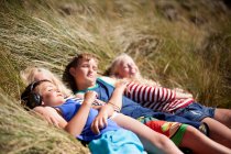 Vier Freunde entspannen in Dünen, Wales, Großbritannien — Stockfoto