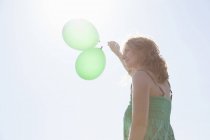 Woman holding two green balloons, Wales, UK — Stock Photo