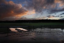 Terrain de football au crépuscule avec ciel dramatique — Photo de stock