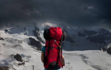 Вид сзади факелоносца, любующегося штормовыми горами — стоковое фото
