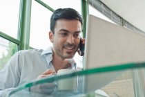 Young male office worker talking on mobile phone — Stock Photo