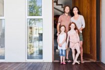 Familie lächelt vor der Haustür — Stockfoto