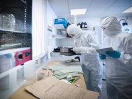 Scientifiques légistes prélever des échantillons de sang dans les vêtements en laboratoire — Photo de stock