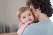 Pai abraçando bebê em casa — Fotografia de Stock