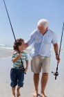 Чоловік і онук з рибальськими полюсами, вибірковий фокус — стокове фото