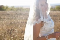 Sposa appena sposata in piedi nel campo — Foto stock