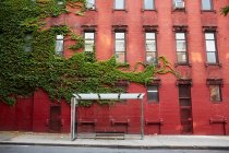 Bushaltestelle und rotes Backsteingebäude — Stockfoto