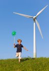 Boy with pinwheel by wind turbine — Stock Photo
