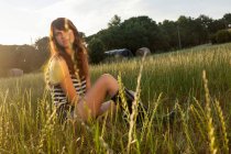 Mujer sentada en un campo de hierba - foto de stock